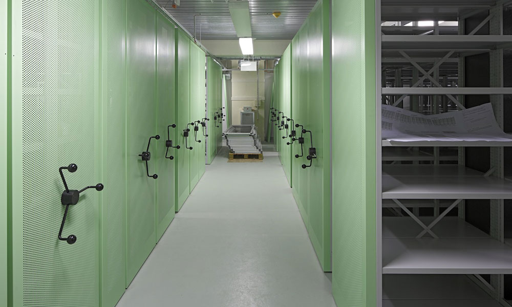 Verfahrbare Archivregale mit Drehsternantrieb und grünen gelochten Vorsatzwänden
